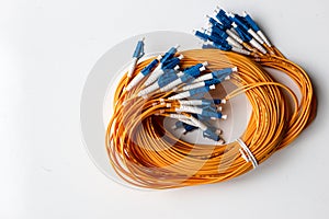 Yellow optical fiber network cable with blue connectors isolated on white background