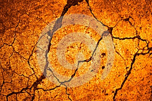 Yellow orange broken concrete wall of an old building with cracks. Close-up. Background.