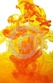 A yellow, orange cloud of ink in water isolated on a white background