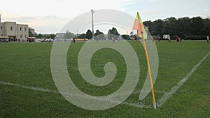 Yellow and orange flag on football pitch corner. Flag waving in corner at stadium soccer football field. Soccer game. Sport concep
