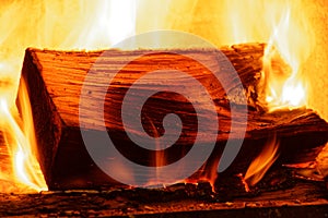 Yellow and orange flames flicker around a burning log.