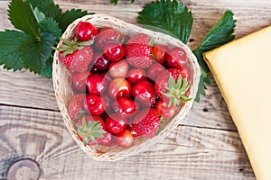 Fresh cherries and red ripe strawberries on a white plate