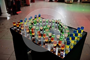 Yellow, orange and green shots on mirror table