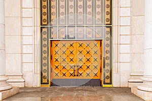 Yellow orange large wooden doors decorated with metal stars. Close-up. Astana Opera and ballet Theatre. Astana Nur-Sultan,