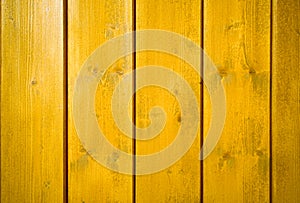 Yellow orange painted wooden wall plank perpendicular to the frame as simple saturated intense yellow color wood background