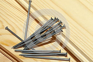 yellow-orange pine wood board and steel nails during construction work