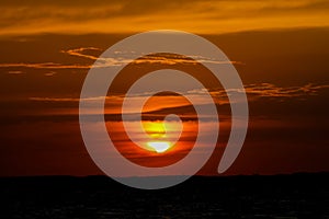 Solar eclipse at sunset across the sky above the sea