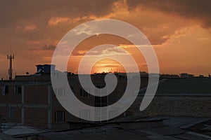 Yellow and orange sunset wiew over a rooftop suburb house