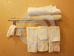 Yellow or orange wall with white towels hanging on rack in bathroom