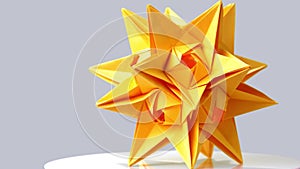 Yellow origami star on gray background.