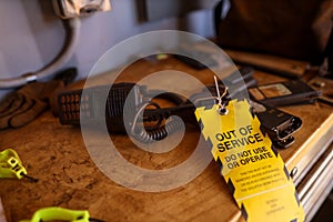 Yellow out of service tag attached on defect broken two way radio on the table do not use or operation