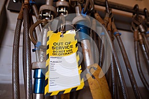 Yellow out of service warning tag sign placing on damaged faulty unsafe to use