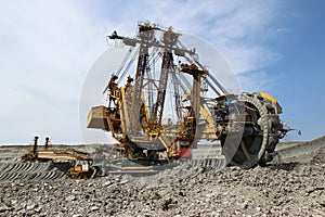 Yellow overburden excavator in brown coal mine photo