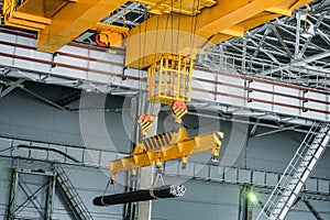 Yellow overhead crane carries cargo in engineering plant shop photo