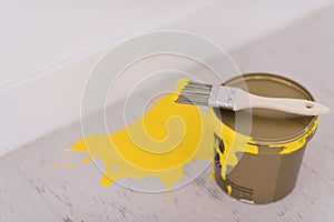 Yellow paint tin can with brush on top