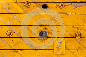 Yellow painted old wooden boards with holes. Natural wood texture. Abstract background