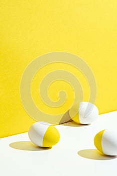 Yellow painted white easter eggs on yellow and white background