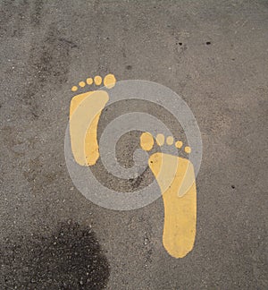 Yellow painting feet symbol on road