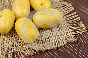 Yellow pale potato on brown wood