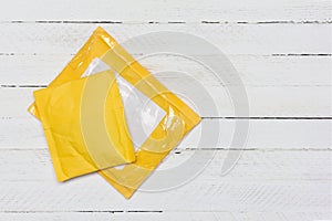 Yellow paper bags from Chinese online stores on white wooden background, top view