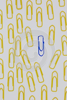 yellow paper clips that goes in one direction and make way for a blue paper clip that goes to the opposite direction, symbolizing