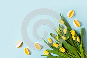 Yellow paper crafting eggs on blue background, easter and spring concept