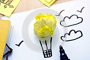 Yellow paper in form of air balloon as dreams. Procrastination or vacation. photo