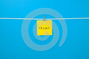 Yellow paper note on clothesline with text Friday