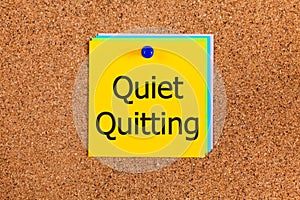 Yellow paper note with words Quiet Quitting on a cork board