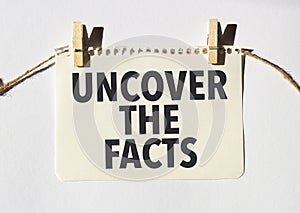 yellow paper sheet with uncover the facts words