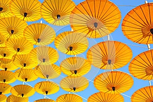 Yellow paper umbrella floating in the blue sky texture.