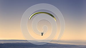 Yellow paragliding on pastel sky