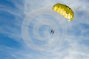 Yellow parasail wing flying over turquoise water.