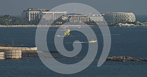 Yellow Parasail Wing Pulled By Boat. Sea Summer Recreation. Parachuting In Turkey. Parasailing With Boat Over Sea In