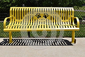 Yellow park bench with paw print cutout