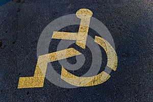 Yellow parking space for disabled people near store. Picturing person in a wheelchair.