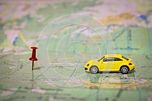A yellow passenger car travels by geographic map. Route of movement on the world map. The concept of travel. Selective focus