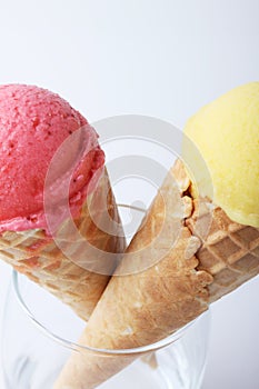 Yellow passion fruit and red strawberry ice cream cones