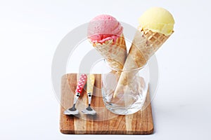 Yellow passion fruit and red strawberry ice cream cones