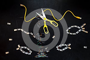 Yellow patch cord cut by scissors and connectors RJ45 , composition isolated over the black chalkboard background.