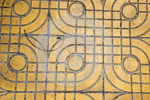 Yellow patterned paving tiles on the street, top view. Cement bricks, squared stone ground floor background texture