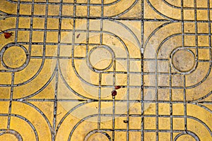 Yellow patterned paving tiles on the street, top view. Cement bricks, squared stone ground floor background texture