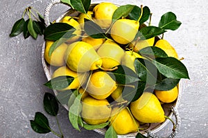 Yellow pear in grey basket in grey background. Harvest. Top view. Full box of pears.