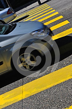 Yellow pedestrian crossing on black pavement