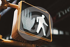 Yellow pedestrian crossing sign with walk light on in New York, Manhattan.