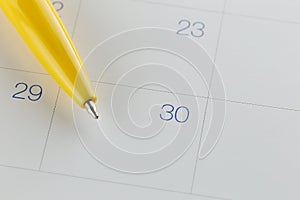 yellow pen points to the number 30 on calendar background.