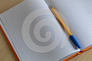 Yellow Pencil Laying on Open Blank Notebook