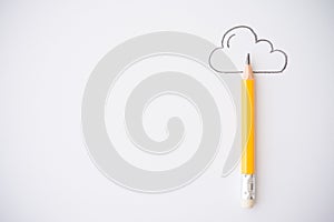 Yellow pencil and outline cloud on white paper background copy space. Creative idea, imagination and education concept.