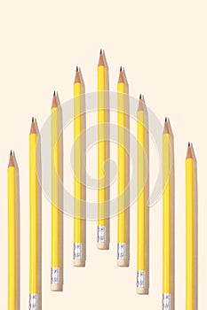 Yellow pencil in a row on beige paper background and copy space for your text