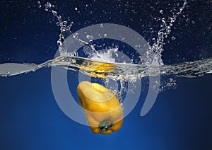 Yellow pepper falling into water